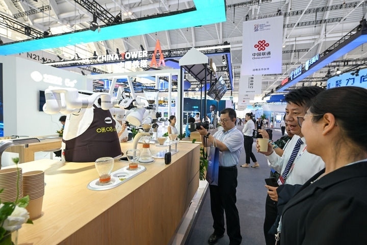 6月20日，與會者品嘗機器人沖調(diào)出的咖啡。新華社記者 孫凡越 攝