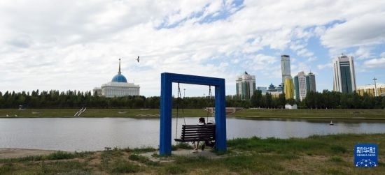 6月30日，一名女子在哈薩克斯坦首都阿斯塔納伊希姆河畔休息。新華社記者 王建華 攝