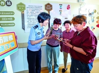 浙江湖州民警指導(dǎo)居民加入湖州“e企安”微信群，實(shí)時接收反詐信息。新華社發(fā)
