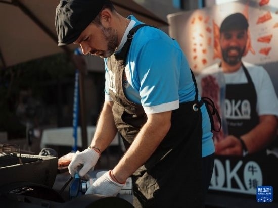 7月19日，在蕪湖古城，馬丁在當(dāng)天舉行的啤酒節(jié)上制作牛排。新華社發(fā)（繆雨晨 攝）