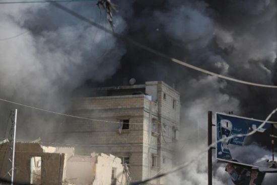 7月21日，在加沙地帶中部的努賽賴特難民營(yíng)，遭以軍空襲的建筑冒出滾滾濃煙。新華社發(fā)（馬爾萬(wàn)·達(dá)烏德攝）