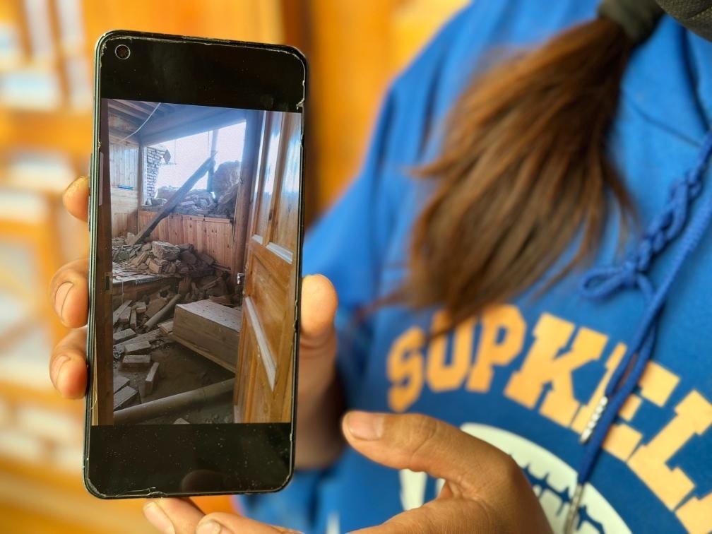 圖為7月17日拉毛東智在手機(jī)上找出地震后房屋受損的照片。新華社記者 張子琪 攝