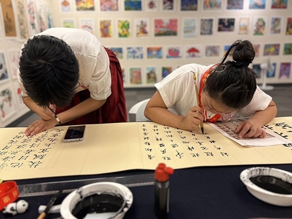 參加本次展覽的青少年在現(xiàn)場進(jìn)行書法創(chuàng)作。主辦方供圖