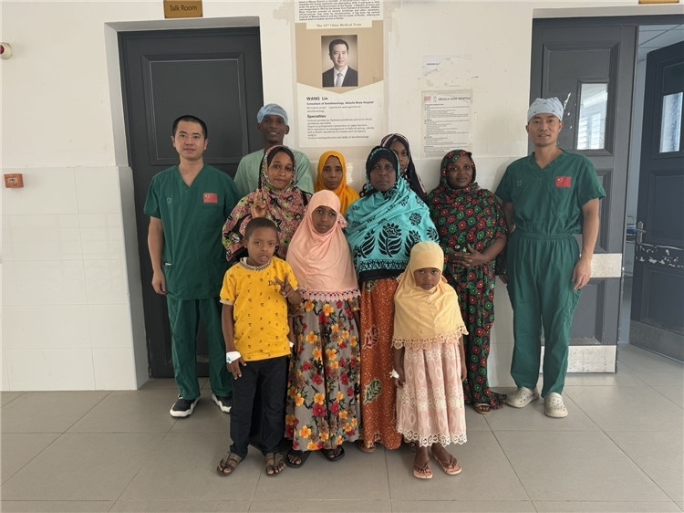 李廣（右一）和王林醫(yī)生與部分患者合影。中國援桑醫(yī)療隊(duì)供圖