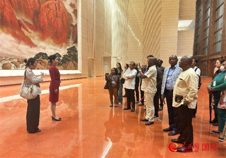 代表團(tuán)在入口處聽取講解。人民網(wǎng) 曹欣悅攝