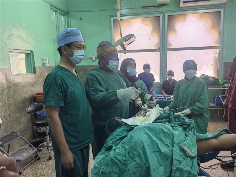隊(duì)長(zhǎng)蔣國(guó)慶（左一）關(guān)注當(dāng)?shù)蒯t(yī)生手術(shù)情況。中國(guó)援桑醫(yī)療隊(duì)供圖