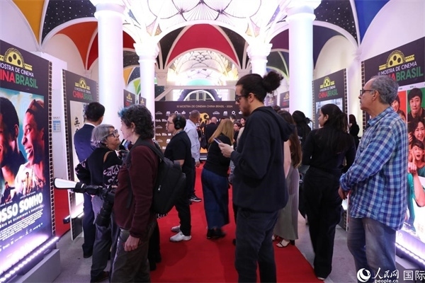為期4天的第三屆中國－巴西電影展期間，來自中巴兩國的14部參展影片受到巴西電影愛好者和社會各界人士好評，圖為當(dāng)?shù)赜^眾在影展舉辦地巴西里約熱內(nèi)盧勞拉—阿爾維姆文化之家的迎賓廳欣賞參展電影海報(bào)。 人民網(wǎng)記者 陳一鳴攝