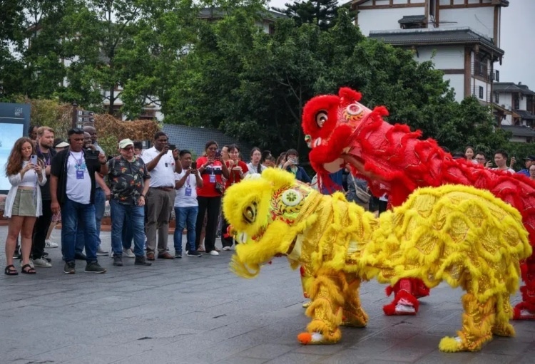 2024“一帶一路”媒體合作論壇聯(lián)合采訪調(diào)研行成員在樂山蘇稽古鎮(zhèn)觀看非遺舞獅表演。本報記者 伊霄攝