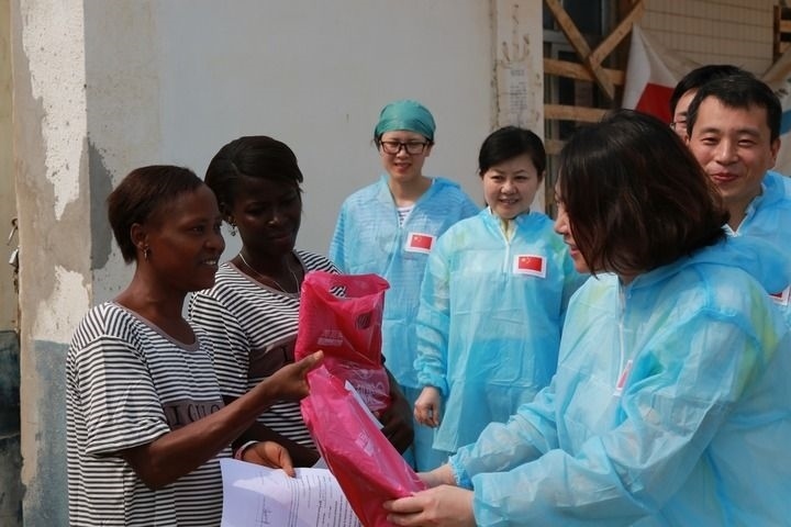 2015年4月4日，在位于塞拉利昂首都弗里敦市郊的中塞友好醫(yī)院埃博拉診療中心，中國第四批援塞醫(yī)療隊(duì)副隊(duì)長邵蔚（右前）向被治愈的埃博拉出血熱患者贈送禮物。新華社發(fā)（祖榮強(qiáng) 攝）