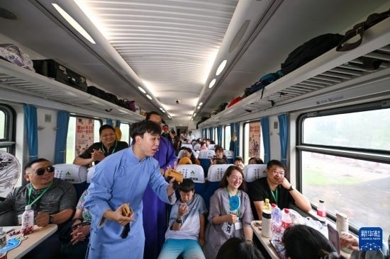 9月7日，相聲演員在S910列車上為旅客表演快板。