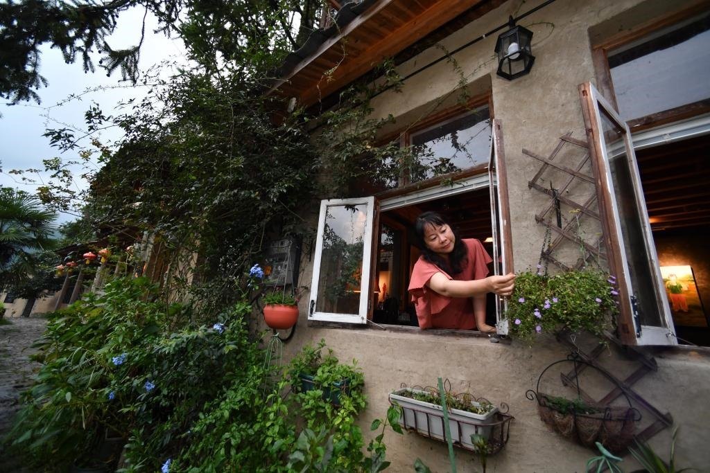 8月29日，在福建省屏南縣熙嶺鄉(xiāng)，龍?zhí)洞濉靶麓迕瘛泵泛暝诖蚶碜约航?jīng)營的民宿外墻裝飾花盆。新華社記者姜克紅 攝