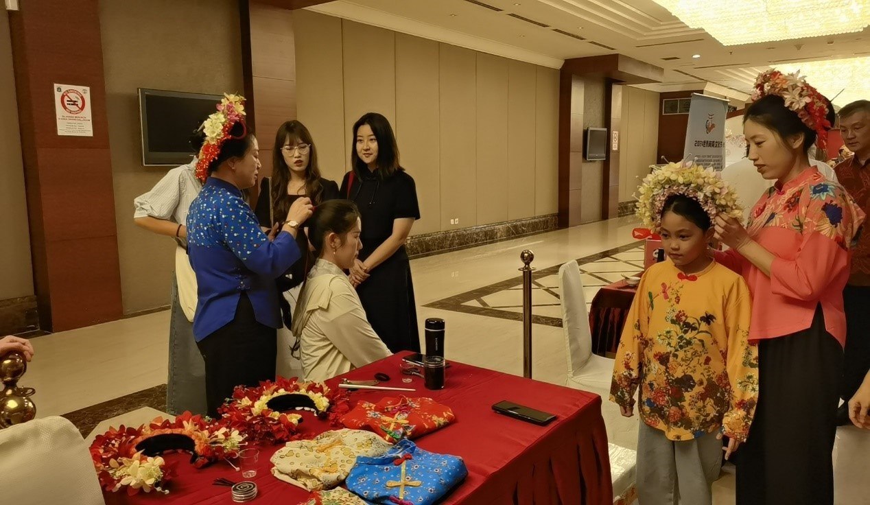 阿拉扎大學(xué)孔子學(xué)院志愿者老師向傳承人學(xué)習(xí)簪花圍。阿拉扎大學(xué)孔子學(xué)院供圖