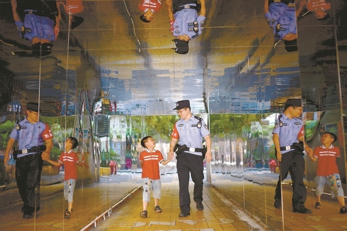 ?7月16日，重慶市公安局江北區(qū)分局一名民警在巡邏途中遇到一個(gè)獨(dú)自玩耍的小男孩，民警將其送回家。王洪平攝