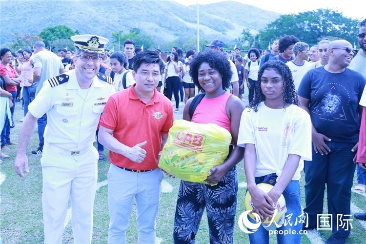 巴西中國浙江商會會長鄭俠茂向巴西貧困社區(qū)兒童及家庭捐贈基礎(chǔ)食品籃子和足球。人民網(wǎng)記者陳海琪 攝