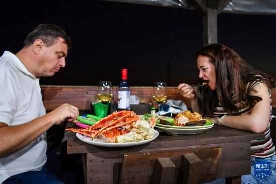 9月2日，食客們在俄羅斯符拉迪沃斯托克的一家餐館品嘗帝王蟹。新華社記者 曹陽 攝