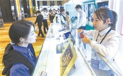 在北京麗澤商務(wù)區(qū)，工作人員（右一）介紹數(shù)字人民幣SIM卡硬錢包。新京報記者 陶冉攝