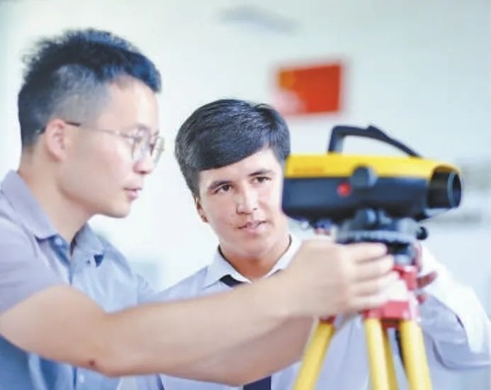 在塔吉克斯坦首都杜尚別的魯班工坊，來自天津城市建設管理職業(yè)技術學院的老師（左）為當?shù)貙W生提供指導。新華社記者 鄭開君 攝