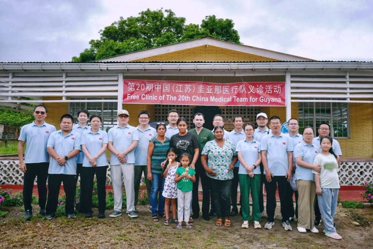 第20期中國(guó)（江蘇）援圭亞那醫(yī)療隊(duì)在圭偏遠(yuǎn)的林登高速社區(qū)開(kāi)展義診后，與部分當(dāng)?shù)鼐用窈嫌啊?中國(guó)援圭醫(yī)療隊(duì)供圖