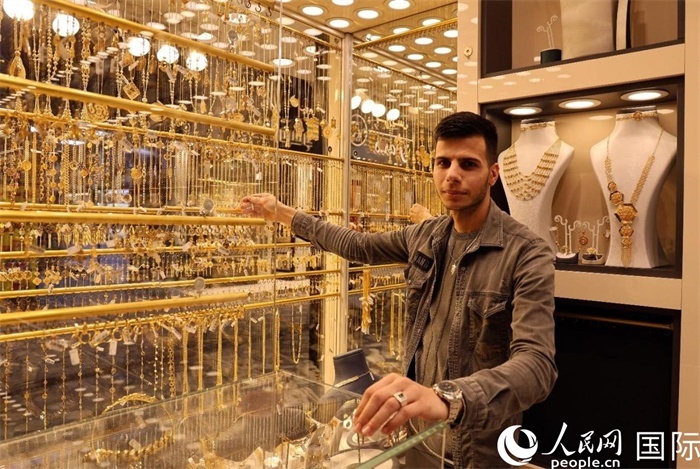 一名銷售員展示黃金飾品。人民網(wǎng) 伊納斯·易卜拉欣攝