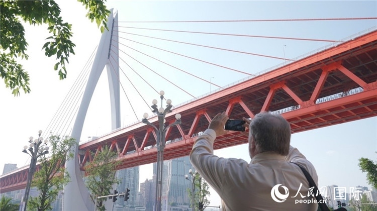 軻寶華“打卡”重慶東水門長江大橋。人民網(wǎng)記者 蘇纓翔攝