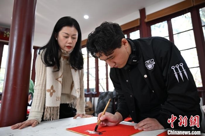 1月20日，外籍留學(xué)生在西泠印社社員李硯指導(dǎo)下寫福。當(dāng)日，來自巴西、馬來西亞、加納、哈薩克斯坦的外籍留學(xué)生在浙江杭州西泠印社體驗福貼、春聯(lián)和篆刻，感受古老的中國傳統(tǒng)文化。中新社記者 王剛 攝