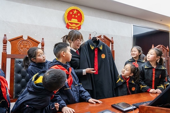 圖②：干警向同學(xué)們介紹法袍。