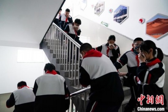  圖為學(xué)生們進(jìn)行應(yīng)急疏散演練。中新社記者 趙宇航 攝