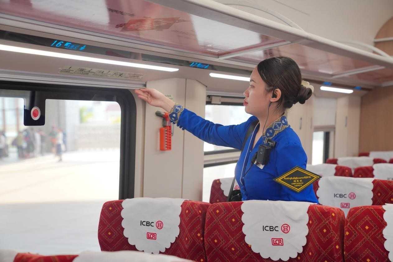 中老鐵路瀾滄號(hào)動(dòng)車組列車長(zhǎng)小麗正在進(jìn)行車廂檢查。老中鐵路有限公司供圖