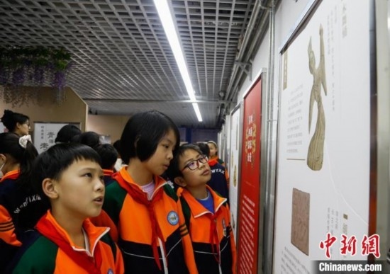 圖為學生參觀青海省博物館“1+3”主題流動展覽，了解木舞俑。中新社記者 馬銘言 攝