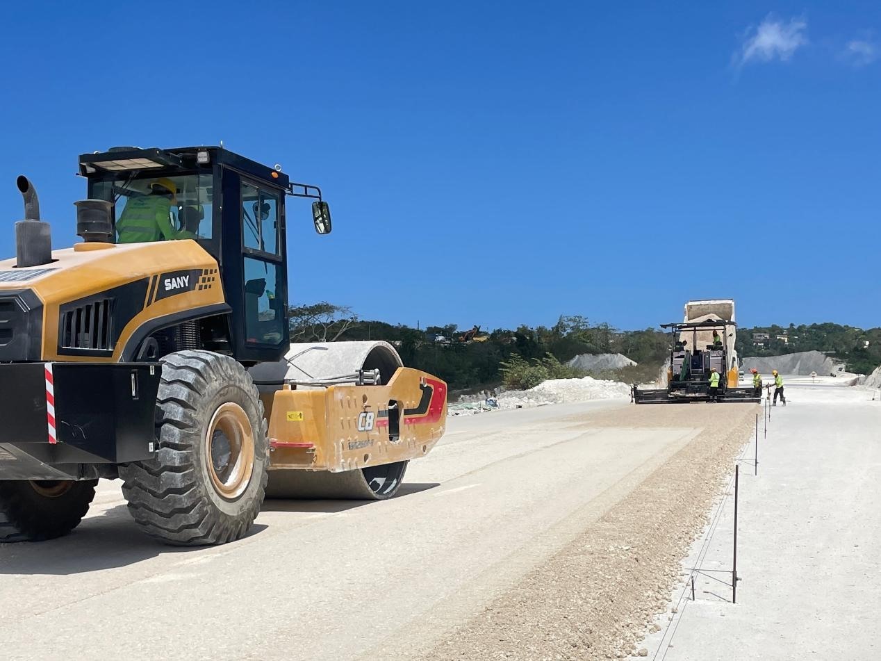 圖為中企承建的牙買加蒙特哥貝繞城路項(xiàng)目基層試驗(yàn)段正在進(jìn)行攤鋪和碾壓施工，相關(guān)施工工作已于日前順利完成。中國港灣美洲區(qū)域公司供圖