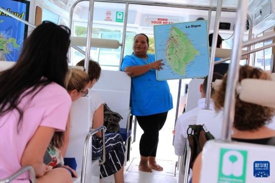 3月15日，一名導(dǎo)游在游艇上為游客介紹塞舌爾拉迪格島。新華社記者 董江輝 攝