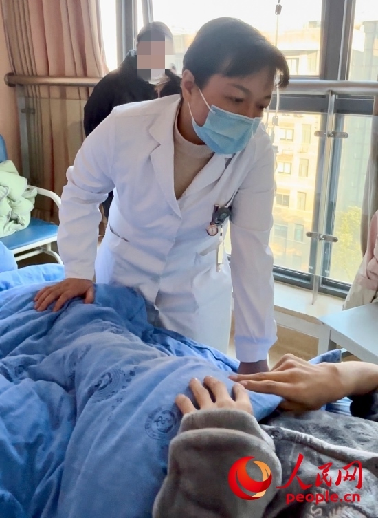 鄧茜查房時(shí)詢問(wèn)患者情況。人民網(wǎng)記者 金慧慧攝