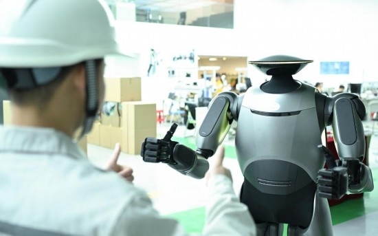 在廣汽研究院，人形機器人團隊的周仁義在演示GoMate機器人互動功能（新華社記者 鄧華 攝）