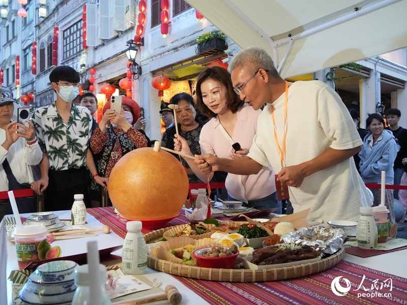 嘉賓品嘗海南傳統(tǒng)美食“煎堆”。人民網(wǎng)記者 張力洋攝