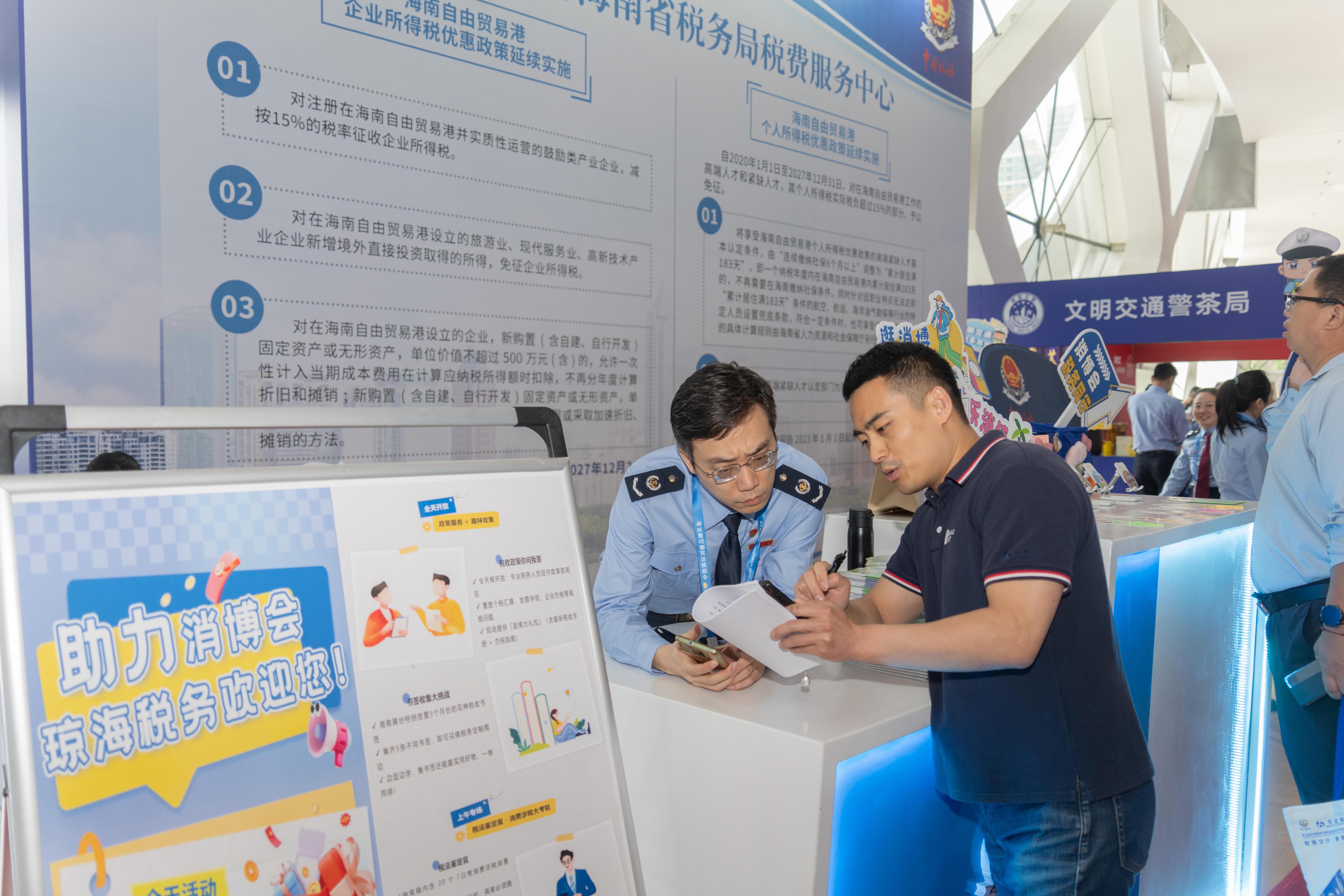 稅務服務臺工作人員向記者介紹服務參展外商的具體舉措。人民網記者 許崢攝