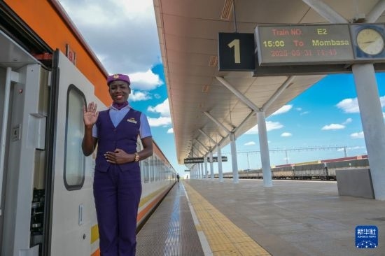 5月31日，在蒙內(nèi)鐵路內(nèi)羅畢站，一名乘務員在即將開往蒙巴薩的E2次列車旁等候乘客。新華社記者 楊光 攝