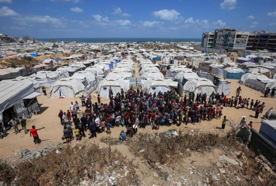 5月28日，人們在加沙城西部的沙提難民營等待領取救助食物。新華社發(fā)（里澤克·阿卜杜勒賈瓦德攝）