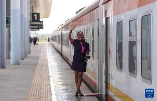 5月31日，在蒙內(nèi)鐵路內(nèi)羅畢站，一名乘務員在即將開往蒙巴薩的E2次列車旁等候乘客。新華社記者 李亞輝 攝